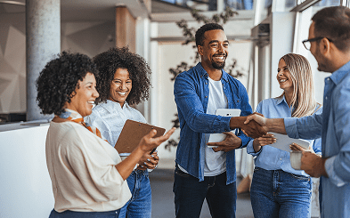 Diverse team shaking hands in workplace
