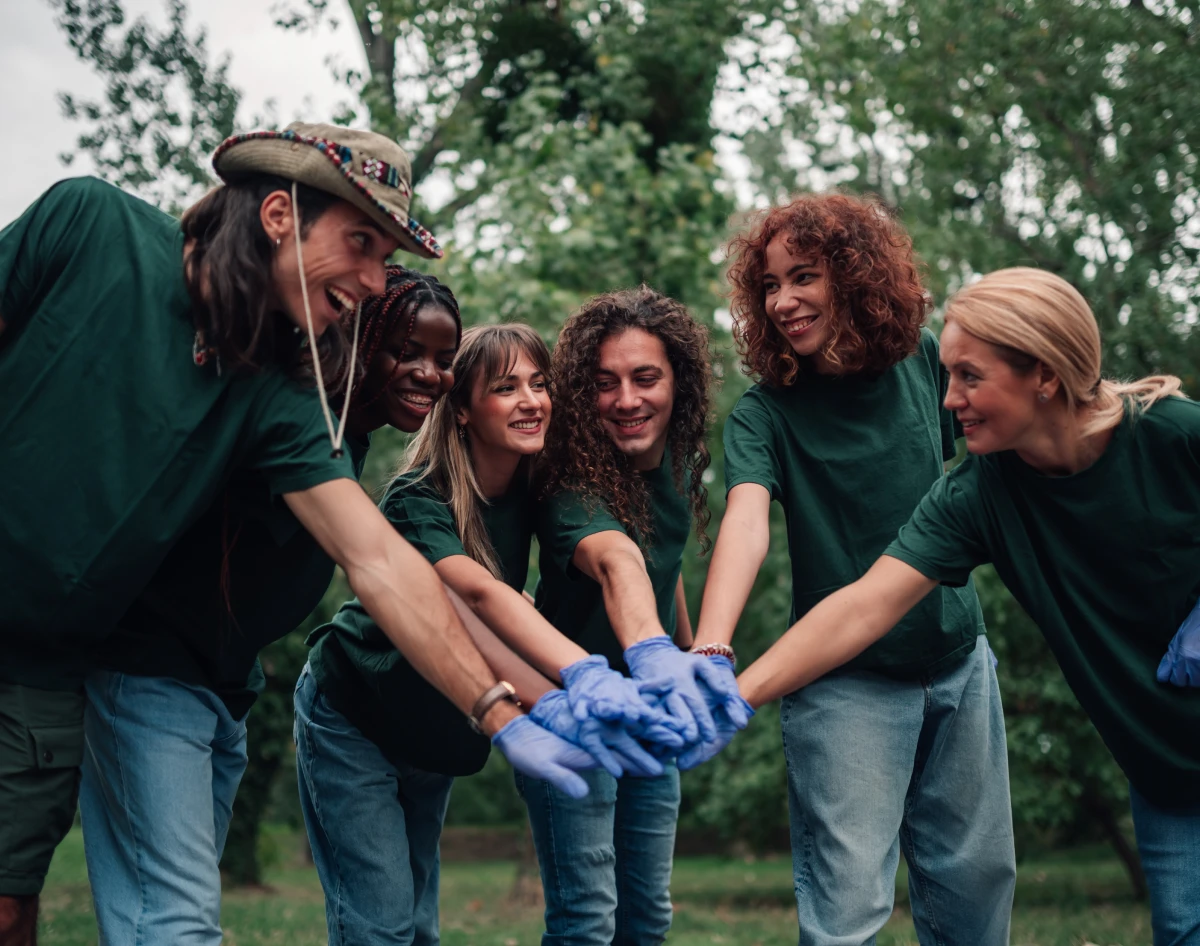Volunteers in a group huddle outdoors